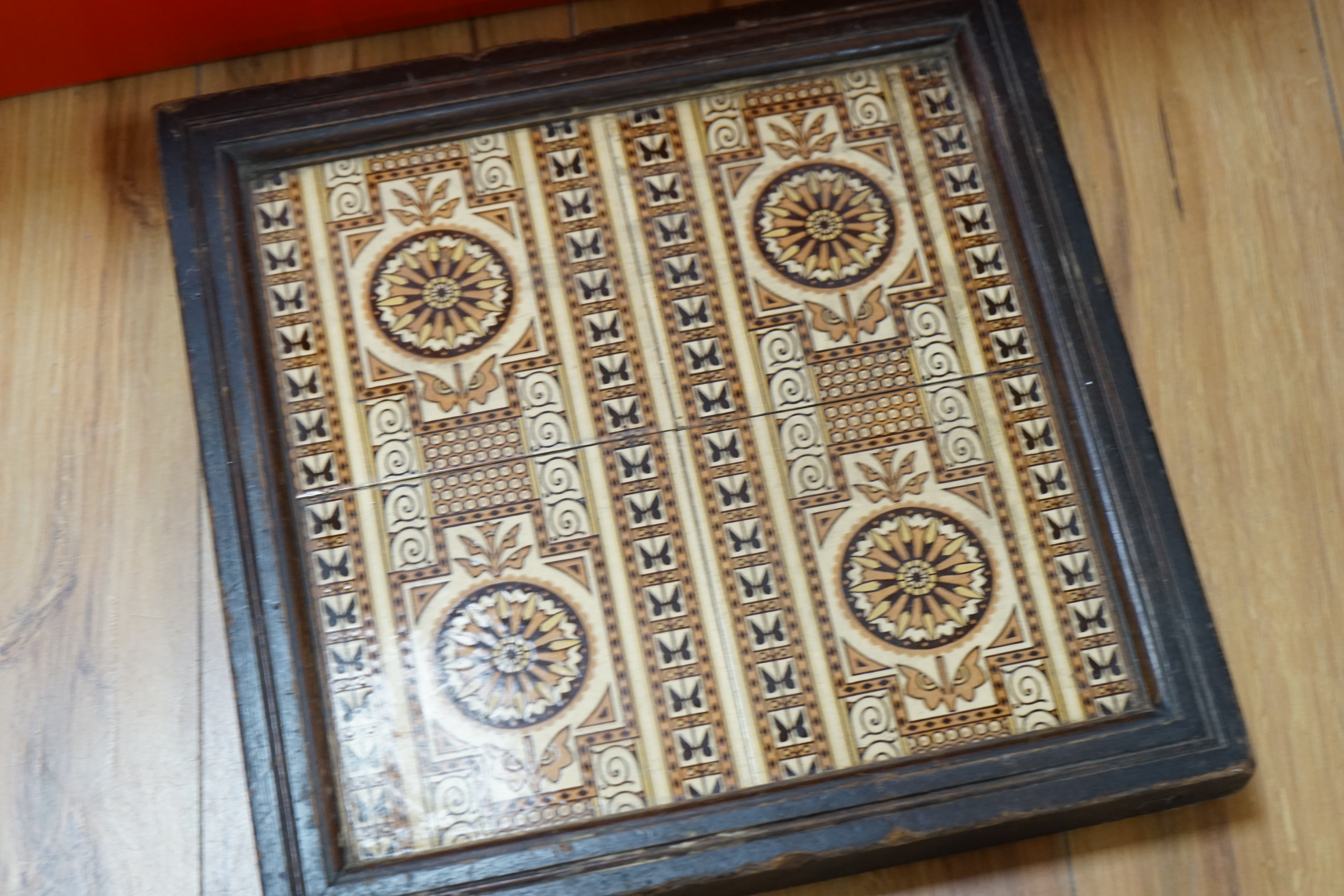 A W N Pugin encaustic tiles by Minton and Co, twenty six and one smaller, together with a group of four similar framed 19th century tiles. Condition - good